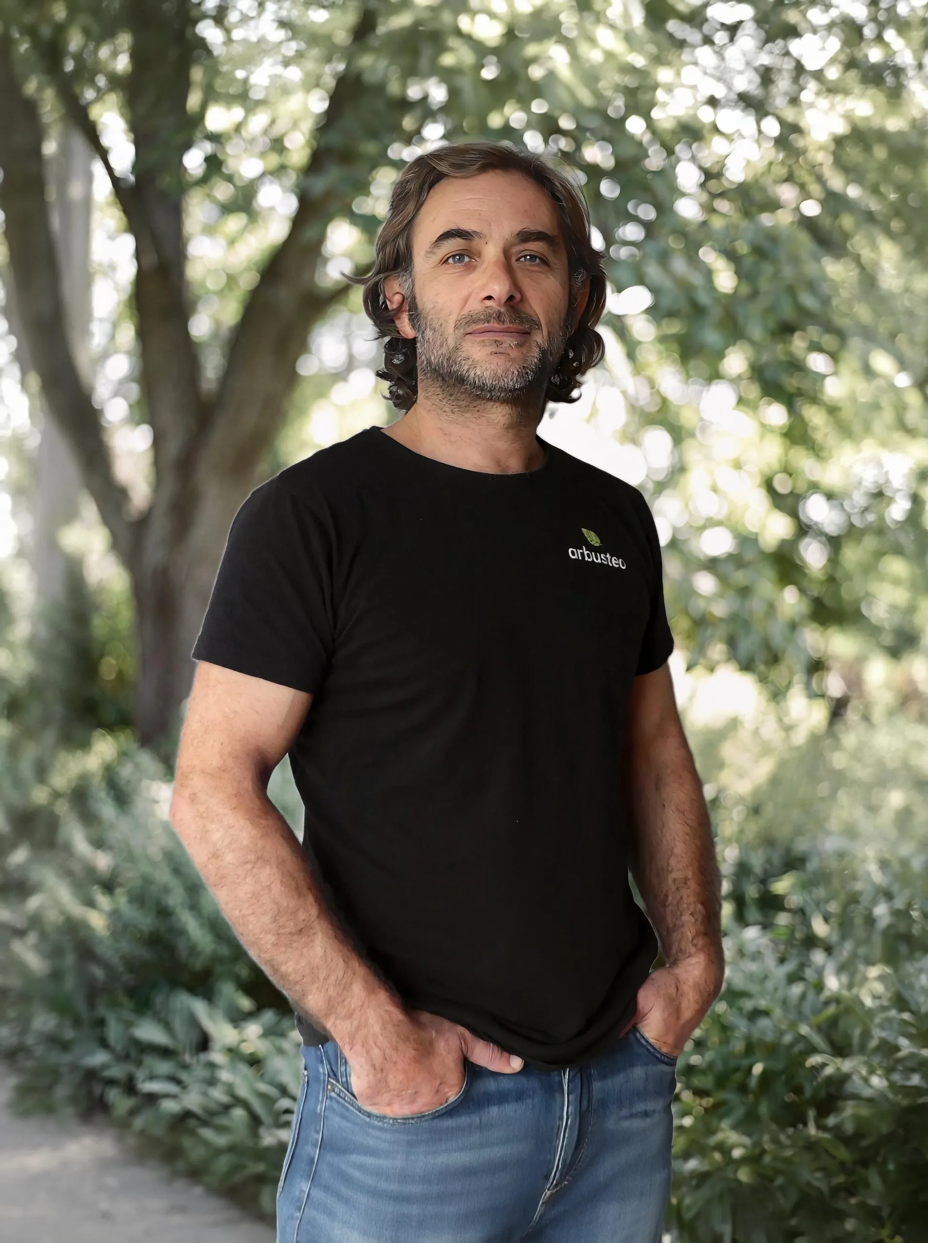 Cédric, fondateur de Canopée Enchantée, en t-shirt arbusteo dans un parc arboré